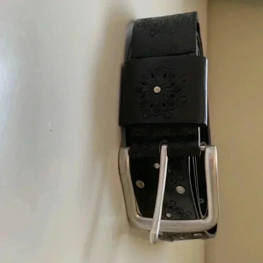 Source  Unknown faux leather belt w embossed floral motif and silver buckle